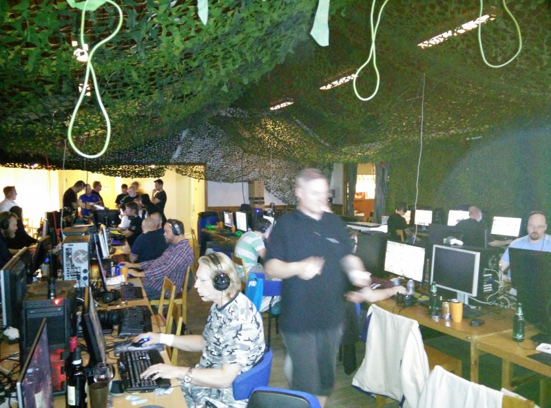Några lirar för fullt på sin platser medan ett gäng samlar sig kring Oculus Rift i bakgrund till vänster. Klart spännande på Gubbklubbens Halloween-LAN 2014